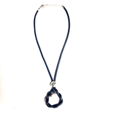 Collar corto largo ajustable con cordon de cuero azul marino, colgante hecho de la misma pieza que el cordón en cuero azul marino y perla cultivada. El cierre es de zamak con baño de plata.